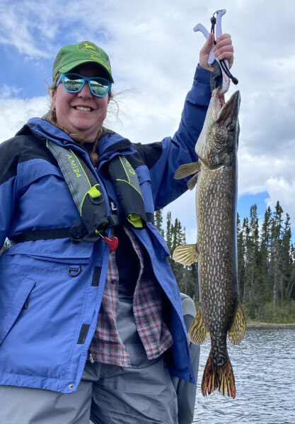 Woman holding a fish freshly caught fish at Woman Lake Lodge Canada