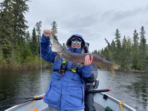Woman holding a fish freshly caught fish at Woman Lake Lodge Canada
