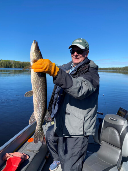 Man holding a fish freshly caught fish at Woman Lake Lodge Canada