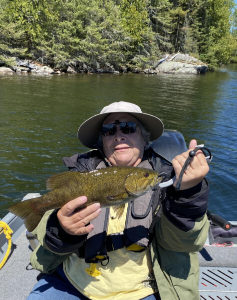 Person holding a fish freshly caught fish at Woman Lake Lodge Canada