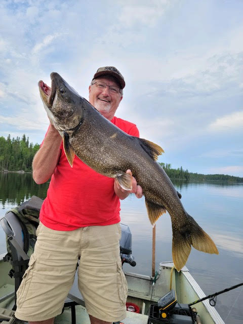 Man holding a freshly caught fish at Woman Lake Lodge