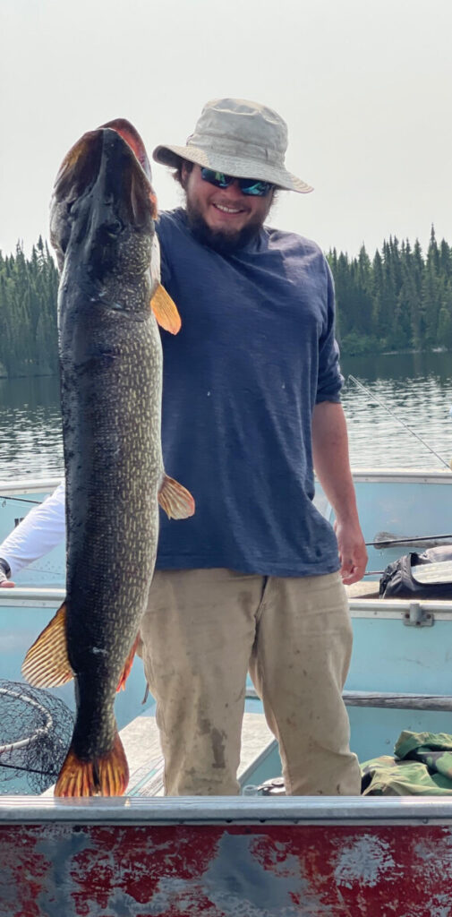 Man holding a massive pike fish at Woman Lake Lodge in Ontario Canada