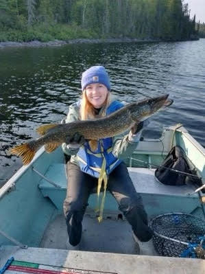 Lady holding a large fish caught at Woman Lake Lodge